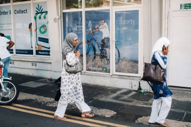 Port Louis, Mauritius: Türbanlı Müslüman kadınlar şehir merkezinde karşıdan karşıya geçiyor.