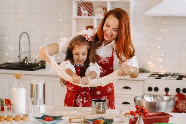 妈妈和女儿在新年厨房里手握圣诞饼干的面团 — 图库照片