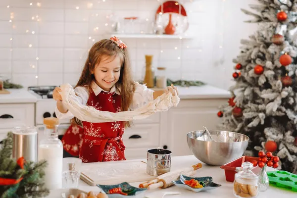 새해초 부엌에 앞치마를 소녀가 크리스마스 쿠키를 반죽을 준비하고 있습니다 — 스톡 사진