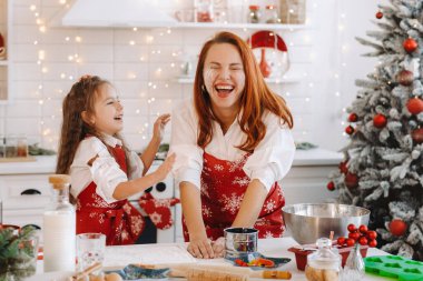 Anne ve kızı yeni yıl mutfağında birlikte Noel kurabiyeleri için hamur hazırlıyorlar..