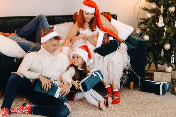 一个快乐的家庭坐在圣诞树旁的沙发上庆祝节日的特写 — 图库照片