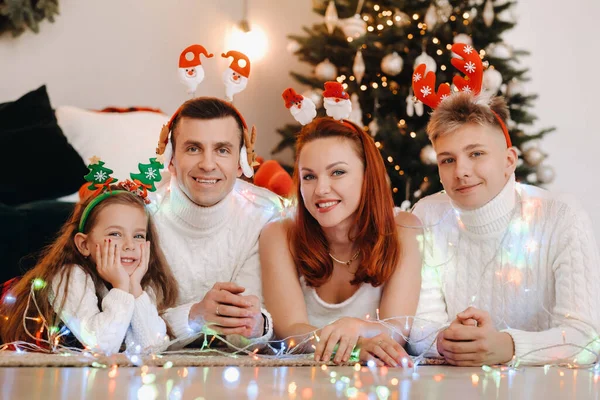 Retrato de close-up de uma família feliz deitada perto de uma árvore de Natal celebrando um feriado — Fotografia de Stock