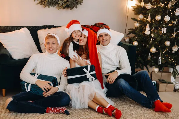 一个快乐的家庭坐在圣诞树旁的沙发上庆祝节日的特写 — 图库照片