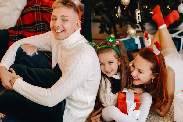 一个快乐的家庭 带着新年的礼物 躺在房子的地板上 旁边是圣诞树 — 图库照片