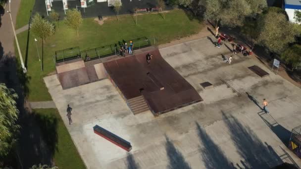 Los niños montan en la pista de skateboard al aire libre.Skatepark para deportes — Vídeo de stock