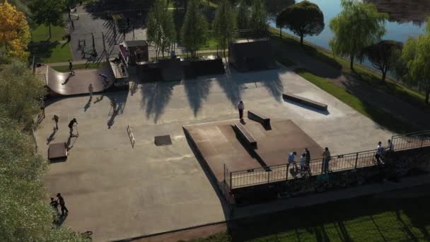 Children ride on the outdoor skateboard court.Skatepark for sports — Stockvideo