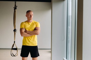 Odaklanmış bir erkek sporcu spor salonunda fonksiyonel döngüler üzerinde bir egzersiz yapıyor..