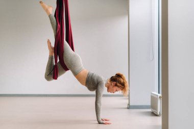 Hamakta asılı bir kadın spor salonunda yoga yapıyor..