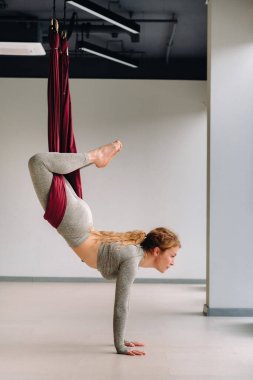 Hamakta asılı bir kadın spor salonunda yoga yapıyor..