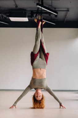 Hamakta asılı bir kadın spor salonunda yoga yapıyor..