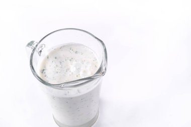 Dereotlu ve maydanozlu bir bardak ayran, beyaz izole edilmiş arka planda. Soğuk yoğurt..
