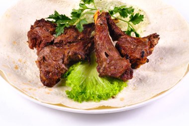 Kaburga üstüne et kebabı, soğan üstüne lahana, beyaz tabakta, izole edilmiş beyaz arka planda..