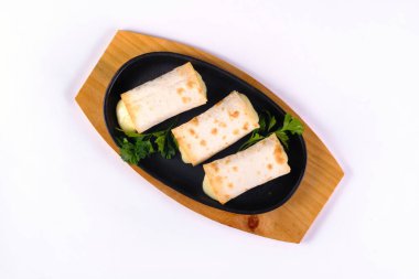 Kızarmış lavaş ruloları, suluguni peyniri, piknik öğle yemeği, aperatifler, izole edilmiş beyaz bir arka planda kızartma tavasında lezzetli yemekler..