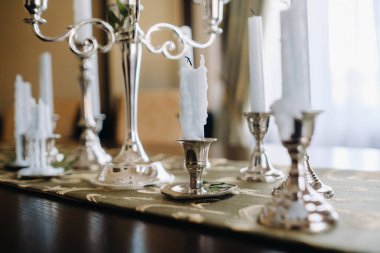 Masanın üzerinde duran şamdanların içinde bir sürü mum var. Mum Işığı Partisi.