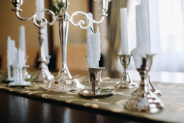 Masanın üzerinde duran şamdanların içinde bir sürü mum var. Mum Işığı Partisi.