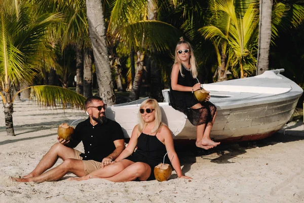 Una Familia Elegante Ropa Negra Con Cocos Sus Manos Playa — Foto de Stock