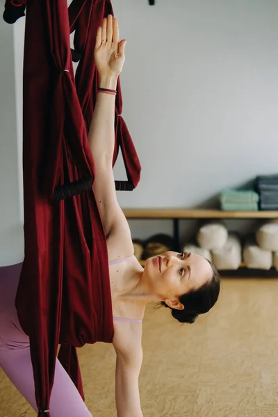 Una Mujer Ropa Rosa Hace Yoga Una Hamaca Borgoña Suspendida — Foto de Stock