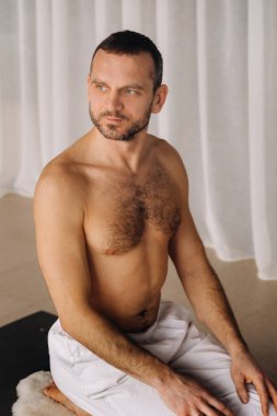 Gövdesi çıplak bir adam spor salonunda yoga yapar. Sağlıklı yaşam tarzı kavramı.