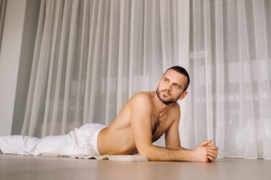 Gövdesi çıplak bir adam spor salonunda yoga yapar. Sağlıklı yaşam tarzı kavramı.