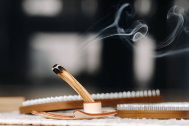 Sigara içen bir Palo Santo sopa ve yoga dersleri için tırnakları olan tahta..