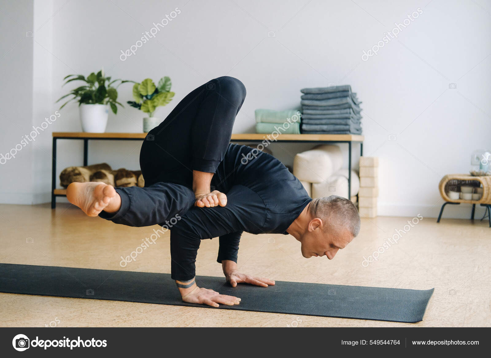 Homme Tenue Sport Noire Fait Yoga Debout Sur Ses Mains Photo de stock par Lobachad 549544764