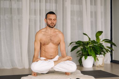 Gövdesi çıplak bir adam spor salonunda yoga yapar. Sağlıklı yaşam tarzı kavramı.