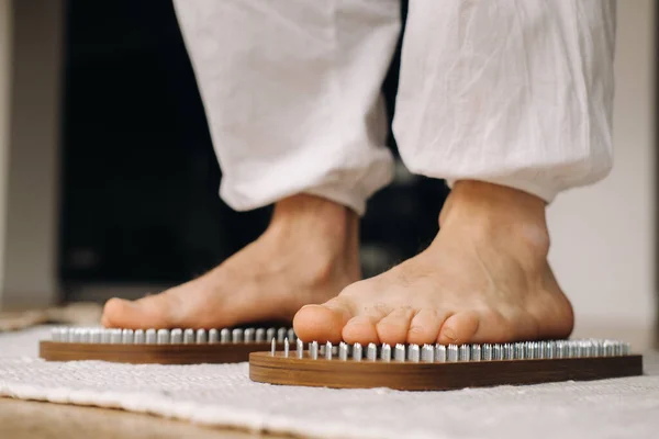 Die Füße Des Mannes Liegen Neben Brettern Mit Nägeln Yoga lizenzfreie Stockfotos