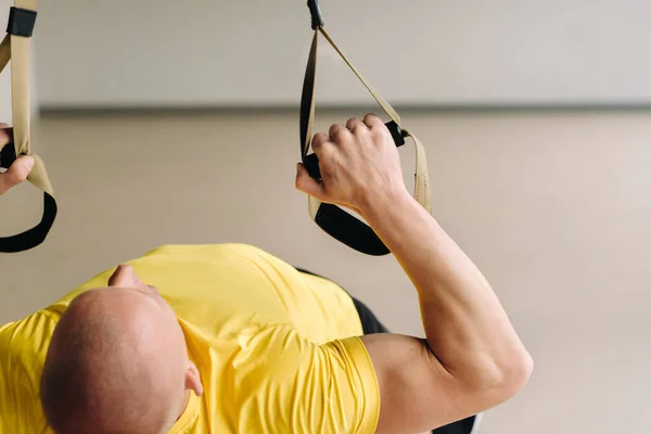 Ein Fokussierter Männlicher Athlet Bei Einer Übung Auf Funktionsschleifen Fitnessstudio lizenzfreie Stockfotos