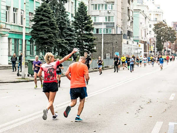 Dnepropetrovsk, Ukrayna - 09.26.2021: Maraton yarışında kent sakinleri. Gönüllüler, koşuculara su ve su dağıtır..