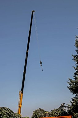 Mavi gökyüzünün arka planında bir vinç patladı. İnşaat konsepti.