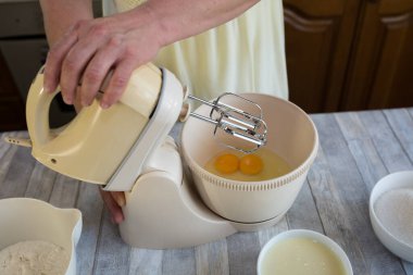 Ekşi kremalı çikolatalı pasta yapma süreci. Hamur hazırlığı. Yumurtalar karıştırıcı kasede çırpılmış. Adım adım çikolatalı pasta tarifi. Pişirme kavramı.