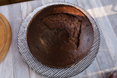Adım adım ekşi çikolatalı pasta yapma süreci. Kadınların elleri fırından bitmiş pastayı çıkarır ve bir tabağa koyar. Pişirme kavramı.