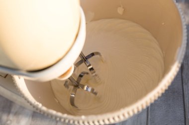 Adım adım ekşi çikolatalı pasta yapma süreci. Ekşi krema hazırlığı. Ekşi krema, şekerli karıştırıcı ile karıştırılır. Pişirme kavramı.