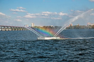 Güzel bir gökkuşağı olan çeşmenin yakın görüntüsü. Mavi gökyüzü arka planı. Su çeşmesinden yapılmış bir gökkuşağı..