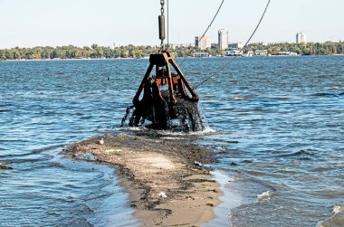 Yeni kurulan adayı Dnieper Nehri 'ndeki endüstriyel atıklardan temizliyorum. Modern nehirlerin çevresel sorunları. Ekoloji kavramı.