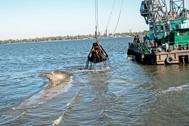 Yeni kurulan adayı Dnieper Nehri 'ndeki endüstriyel atıklardan temizliyorum. Modern nehirlerin çevresel sorunları. Ekoloji kavramı.
