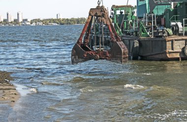 Yeni kurulan adayı Dnieper Nehri 'ndeki endüstriyel atıklardan temizliyorum. Modern nehirlerin çevresel sorunları. Ekoloji kavramı.