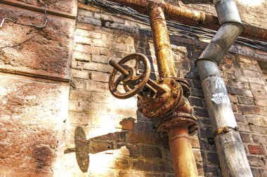 Duvarda eski paslı gaz kontrol vanası var. Büyük bir sistemde endüstriyel bir vana. Ukrayna 'nın gaz iletim sistemi çöküyor..