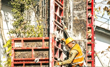 Dnepropetrovsk, Ukrayna - 10.22.2021: İnşaatçı beton bölümler için form ve demir takviyesi veya takviye çubuğu kuruyor. Büyük bir konut inşaatı.