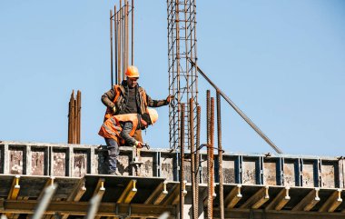 Dnepropetrovsk, Ukrayna - 10.20.2021: İnşaatçı beton bölümler için form ve demir takviyesi veya takviye çubuğu kuruyor. Büyük bir konut inşaatı.