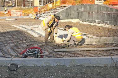 Dnepropetrovsk, Ukrayna - 11.14.2021: İşçiler kaldırım döşemeleri için takviye ağları kuruyorlar. Kaldırımın somutlaşmasının temeli.