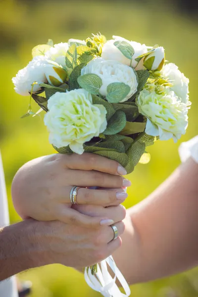 新娘和新郎手拿结婚戒指一对夫妇拿着结婚花束 — 图库照片