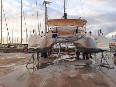 Bodrum, Türkiye - 10.12.2021: Tersanede modern yelken yatı. Tekne marinasının kıyısındaki limana yanaşmış bir spor yatı. Kairos Marina.