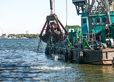 Yeni kurulan adayı Dnieper Nehri 'ndeki endüstriyel atıklardan temizliyorum. Modern nehirlerin çevresel sorunları. Ekoloji kavramı.