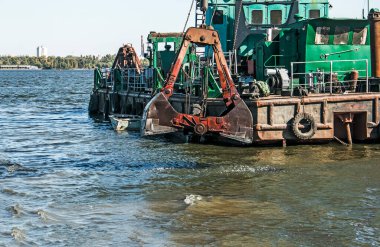 Yeni kurulan adayı Dnieper Nehri 'ndeki endüstriyel atıklardan temizliyorum. Modern nehirlerin çevresel sorunları. Ekoloji kavramı.