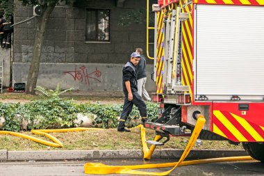 Dnepropetrovsk, Ukrayna -09.20.2021: Beş katlı bir binanın en üst katında yangın. Yangın söndürme sırasında su ve köpük kontrol paneli operatörünün işi.