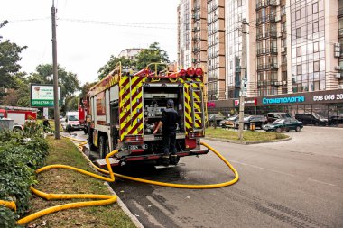 Dnepropetrovsk, Ukrayna -09.20.2021: Beş katlı bir binanın en üst katında yangın. Yangın söndürme sırasında su ve köpük kontrol paneli operatörünün işi.
