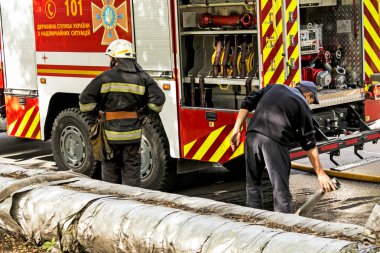 Dnepropetrovsk, Ukrayna -09.20.2021: Beş katlı bir binanın en üst katında yangın. Yangın söndürme sırasında su ve köpük kontrol paneli operatörünün işi.