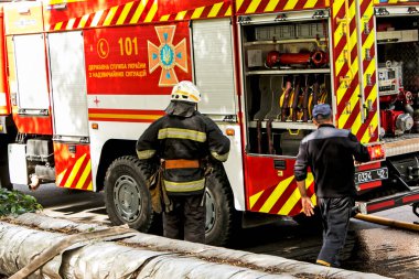 Dnepropetrovsk, Ukrayna -09.20.2021: Beş katlı bir binanın en üst katında yangın. Yangın söndürme sırasında su ve köpük kontrol paneli operatörünün işi.