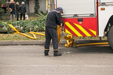 Dnepropetrovsk, Ukrayna -09.20.2021: Beş katlı bir binanın en üst katında yangın. Yangın söndürme sırasında su ve köpük kontrol paneli operatörünün işi.